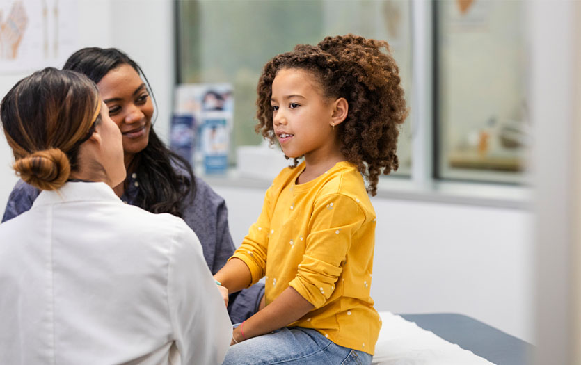 Mother and adolescent speaking with doctor