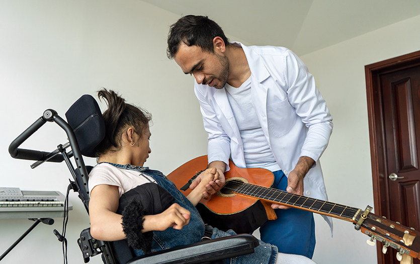 Music therapist showing patient how to use guitar