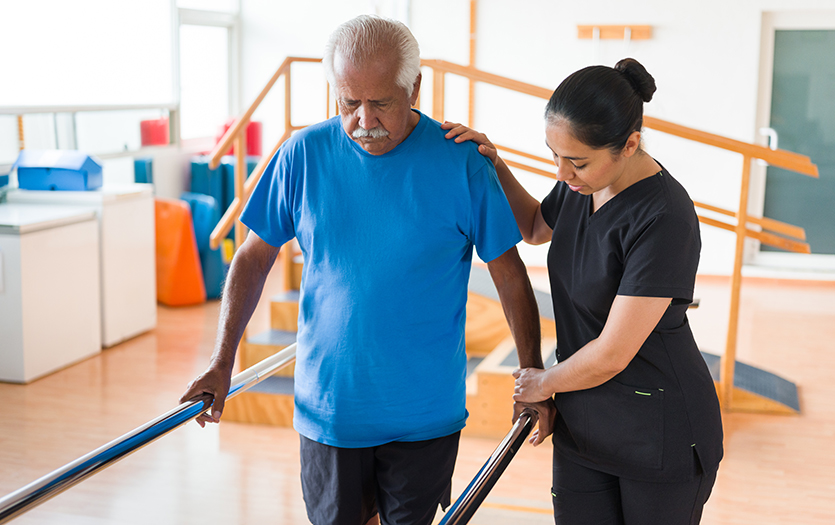 Older man working with physical therapist woman. 