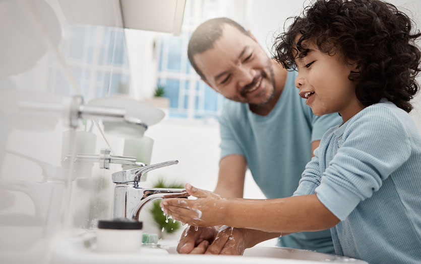 Parent helping child with handwashing