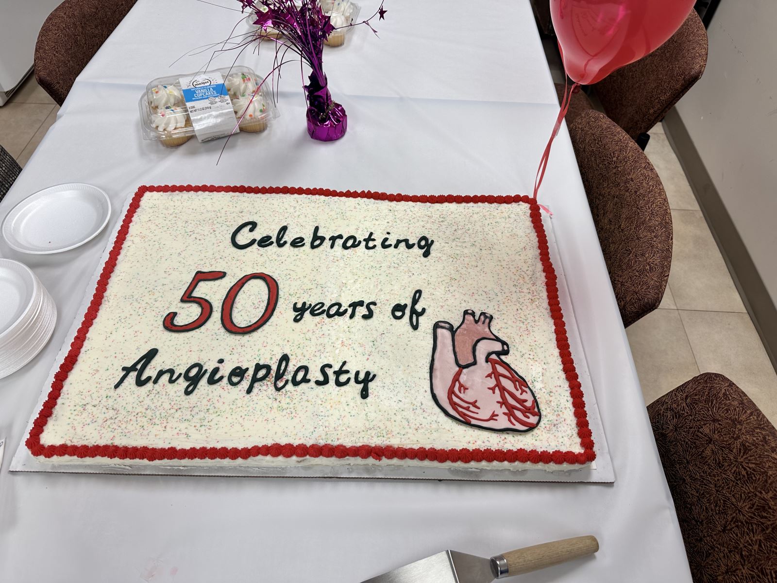 White Cake 50 years if angioplasty written in icing